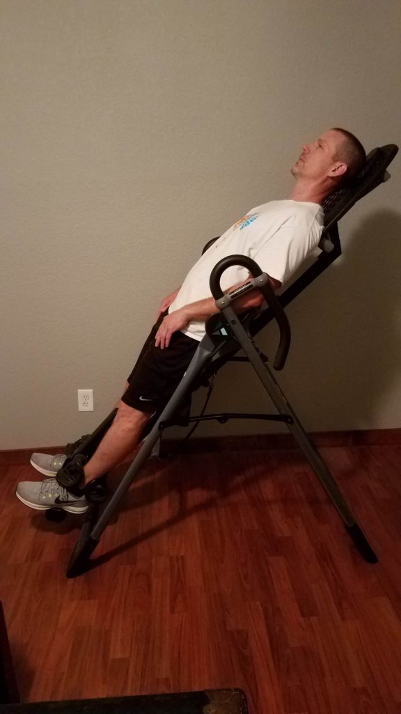 man on a Inversion table in upright position