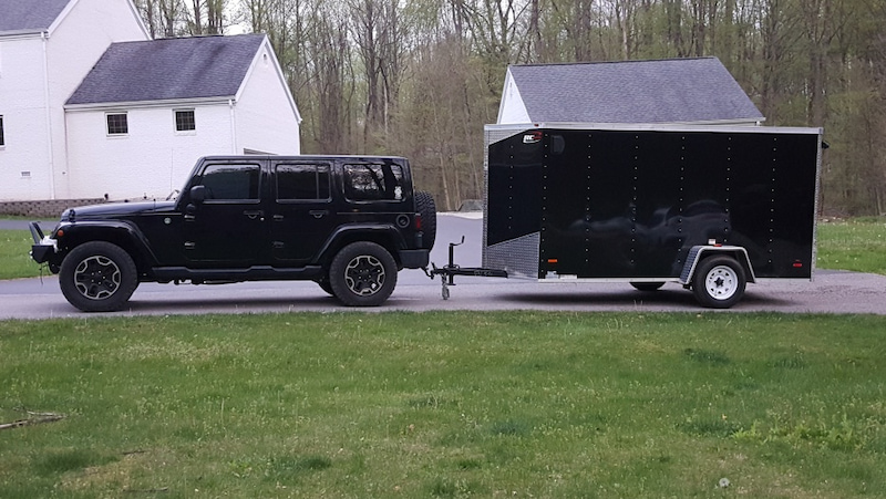 jeep pulling black trailer