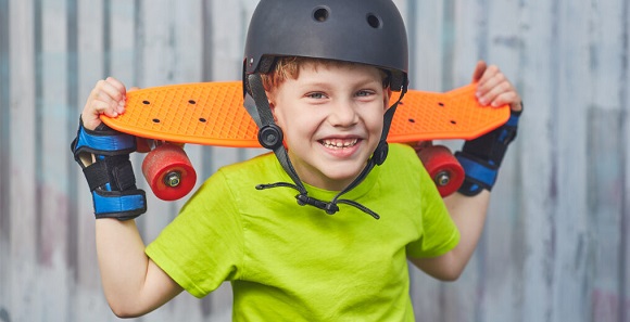 kid with skateboard helmet smiling 