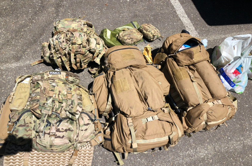 Different kinds of tactical backpacks on the ground