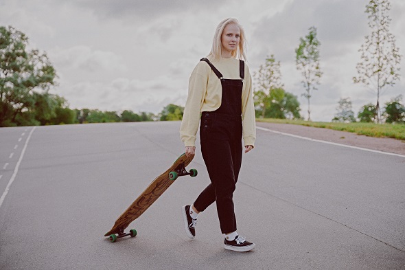 picture of a woman holding a skateboard on a street